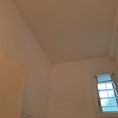 תקרה וקירות צבועים בלבן עם חלון קטן