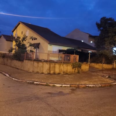 בית פרטי עם גדר ברחוב בשעת ערב