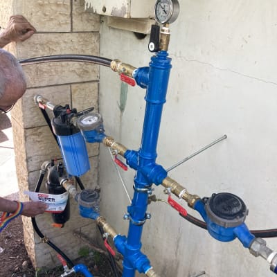 צנרת כחולה עם מד לחץ ושסתומים אדומים