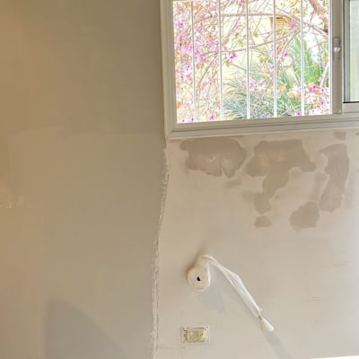 קיר צבוע חלקית עם חלון קטן