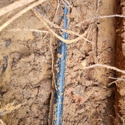 צינור פלסטיק שחור באדמה חפורה