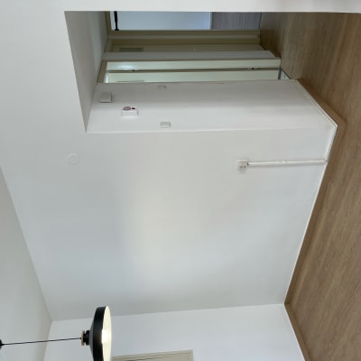 קיר צבוע בלבן עם מנורה שחורה תלויה