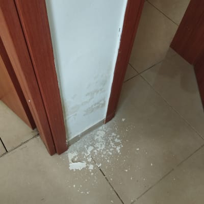 קיר עם קילופי צבע ולכלוך על הרצפה