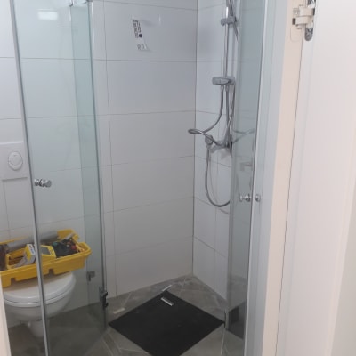 מקלחת עם דלתות זכוכית וראש מקלחת