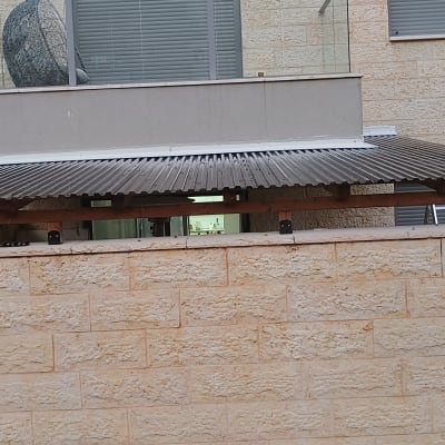 גג עץ עם כלים על קיר אבן