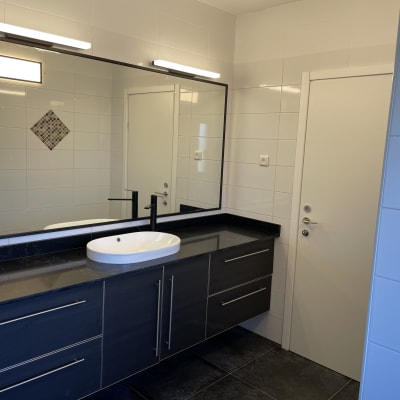 חדר אמבטיה עם כיור, מראה גדולה וארון שחור