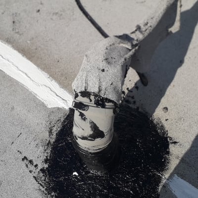 איטום צינור על גג עם חומר שחור ולבן