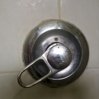 ברז מים עגול עם ידית מתכת על קיר קרמיקה