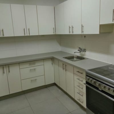 מטבח עם משטח שיש אפור וכיור נירוסטה