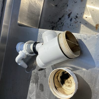 חלקי צנרת פלסטיק מפורקים על כיור מתכת