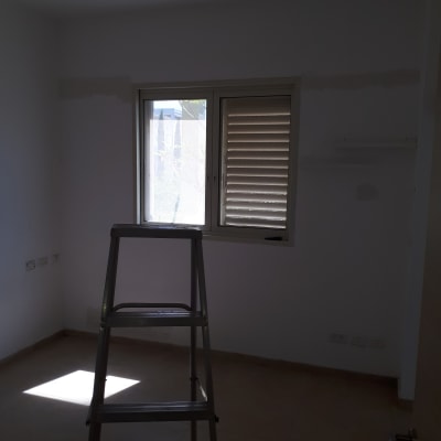 סולם בחדר עם קיר צבוע חלקית