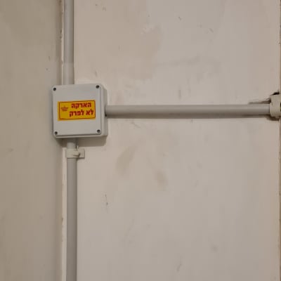 קופסת חיבורים עם כיתוב אזהרה בעברית