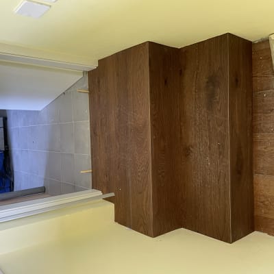 מדרגות עץ כהות מותקנות על רצפת פרקט