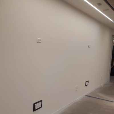 קיר צבוע בלבן עם שקית צבע על הרצפה