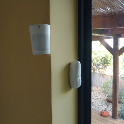 שני חיישני תנועה מותקנים על קיר ליד חלון