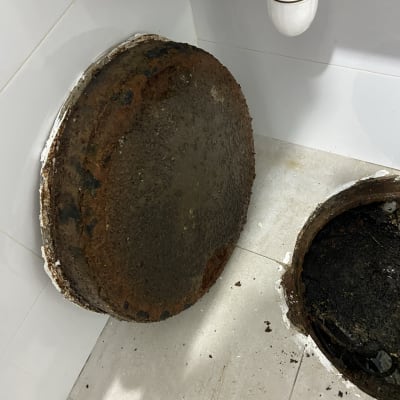 צינור ביוב מתחת לכיור עם מכסה חלוד