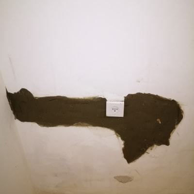 קיר עם תיקון טיח ושקע חשמלי