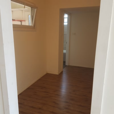 קירות צבועים בלבן בחדר עם רצפת עץ