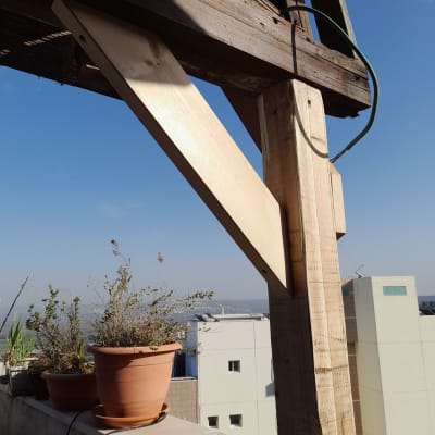 מבנה עץ עם עציצים על מעקה מרפסת