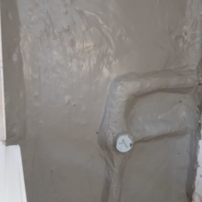 קיר מטויח עם צינור מכוסה בטיח