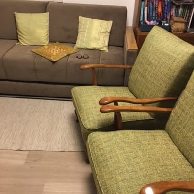 כריות ירוקות על כורסאות עם ידיות עץ