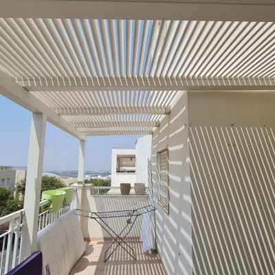 פרגולה מעץ עם צללים על המרפסת