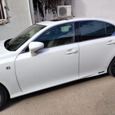 מכונית לבנה עם גלגלים וסמל על הדלת