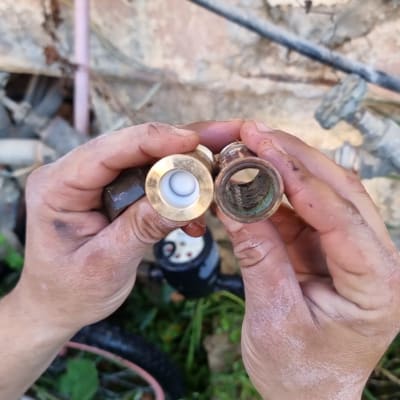 ידיים מחזיקות חלקי צנרת מתכת ישנים וחדשים