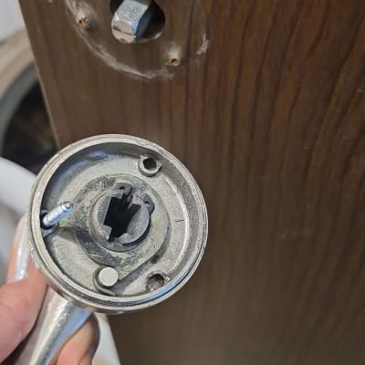 ידית דלת מתכתית מפורקת עם חור בדלת עץ