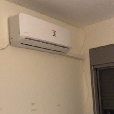 מזגן קיר לבן מותקן על קיר פנימי