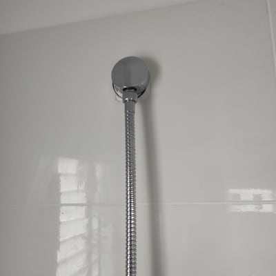 צינור מקלחת מחובר לקיר עם חיפוי כרום