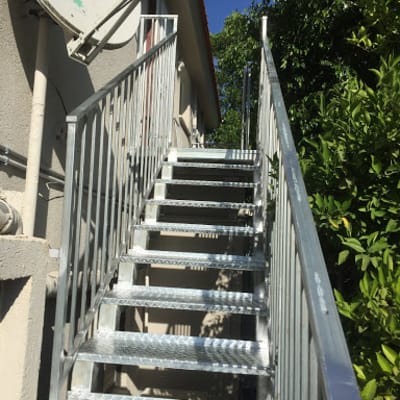גרם מדרגות מתכת עם מעקה בצד ימין