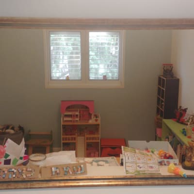 מראה במסגרת עץ עם צעצועים על מדף