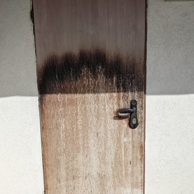 דלת עץ עם קילוף צבע ושחיקה בחלק התחתון