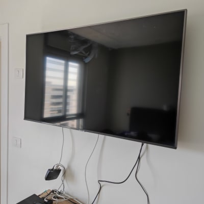 טלוויזיה תלויה על הקיר עם כבלים מחוברים