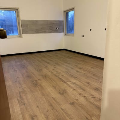 רצפת פרקט עץ בחדר ריק עם חלונות