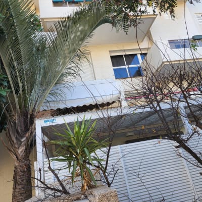 מרפסת עם סוכך לבן מעל חלון