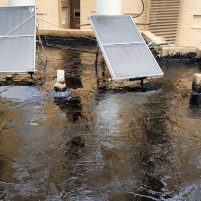 גג אטום בזפת עם קולטי שמש