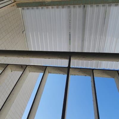 סורגי מתכת מול שמיים כחולים וקיר מרוצף