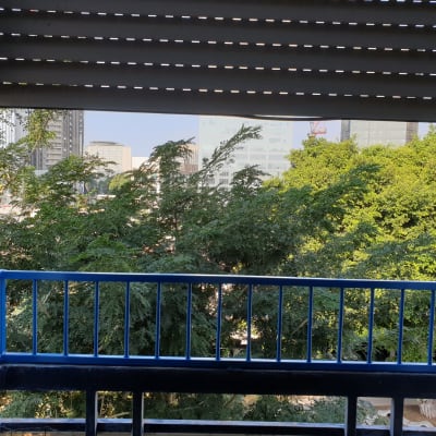 חלון פתוח עם תריסים ומעקה כחול