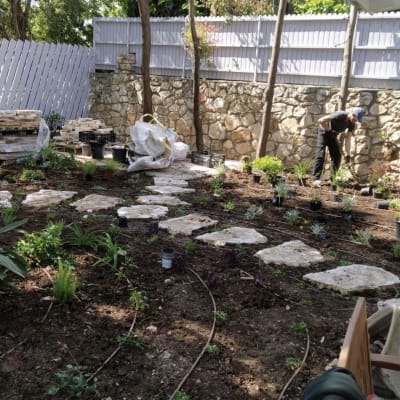 שתילת צמחים בגינה עם אבנים וכלי עבודה