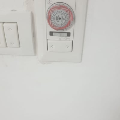 שעון טיימר חשמלי מותקן על קיר לבן