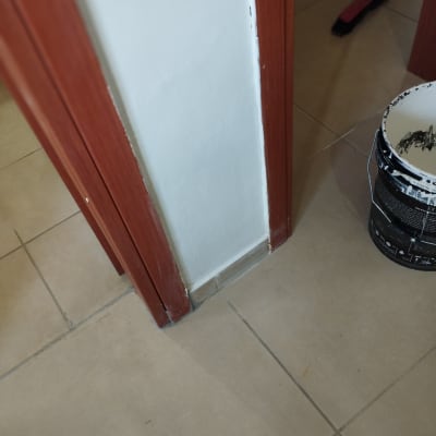 דלי צבע ליד קיר ומשקוף עץ