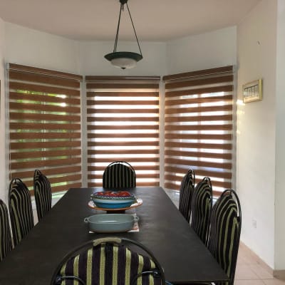 וילונות גלילה חומים על חלונות פינת אוכל