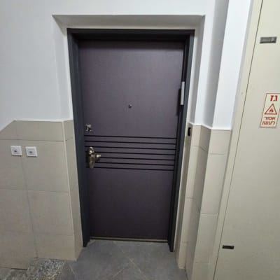 דלת מתכת אפורה עם ידית כסופה