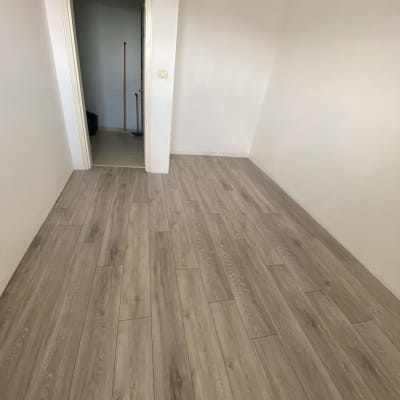 רצפת פרקט עץ בחדר ריק עם דלת פתוחה