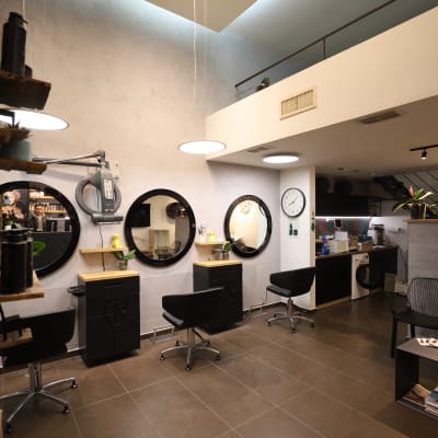 מספרה עם מראות עגולות וכיסאות מסתובבים