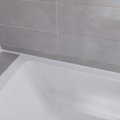 אמבטיה עם אריחים אפורים על הקיר