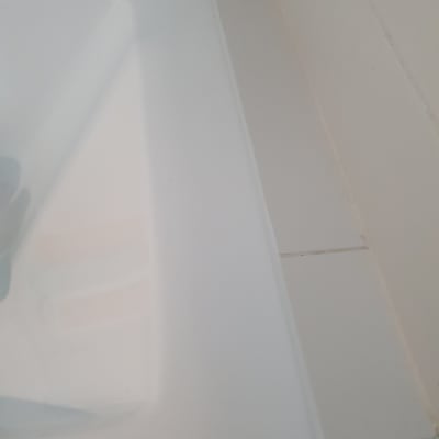 פינת אמבטיה עם אריחים לבנים ותפרים