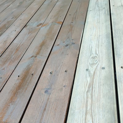 דק עץ בגינה עם לוחות עץ כהים ובהירים